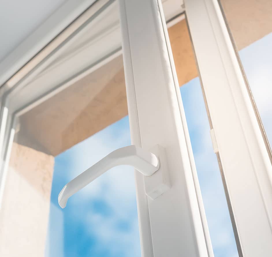 Weißes Fenster mit einem Griff, das den Blick nach draußen ermöglicht und Helligkeit hereinlässt